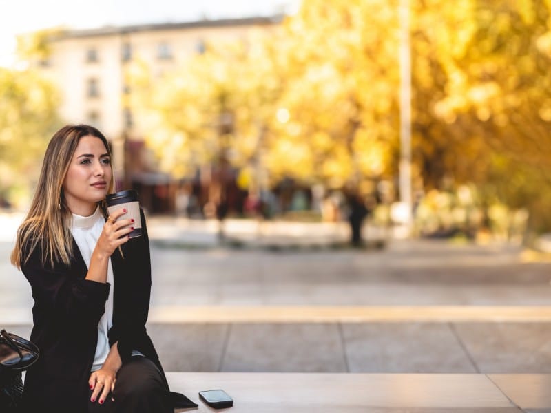 woman sitting outside with a cup of coffee