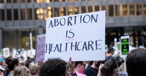 person holding sign that reads abortion is healthcare