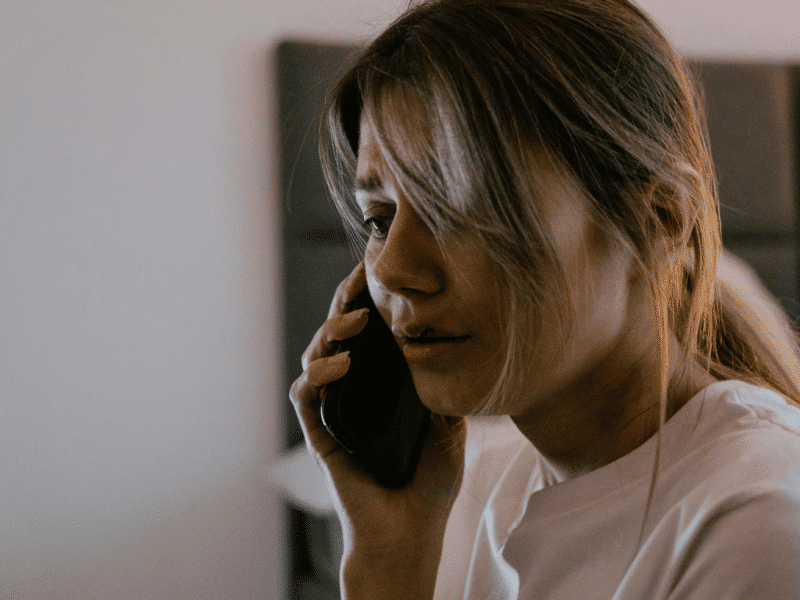 abused woman calling for help on the phone