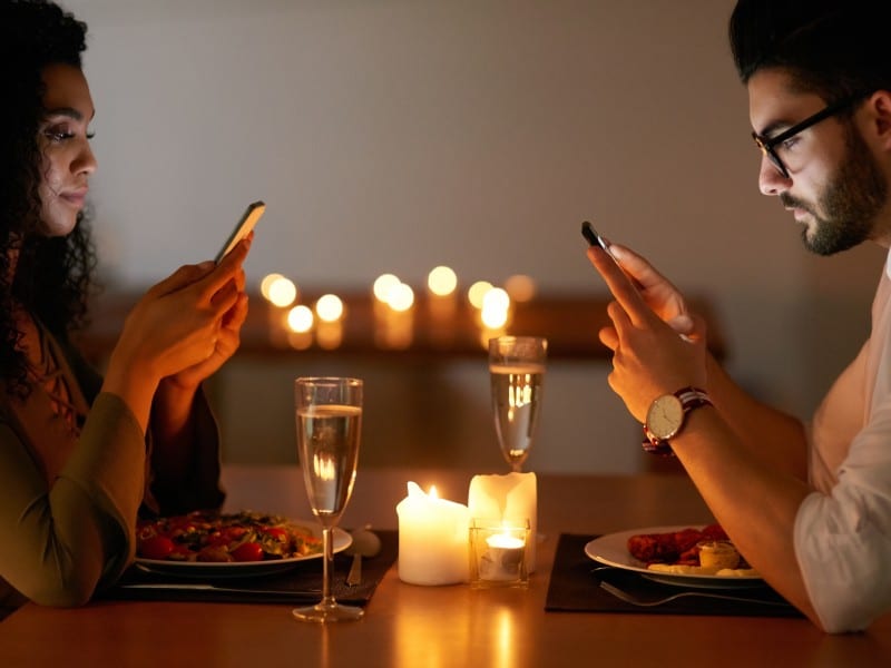 couple at dinner on their phone