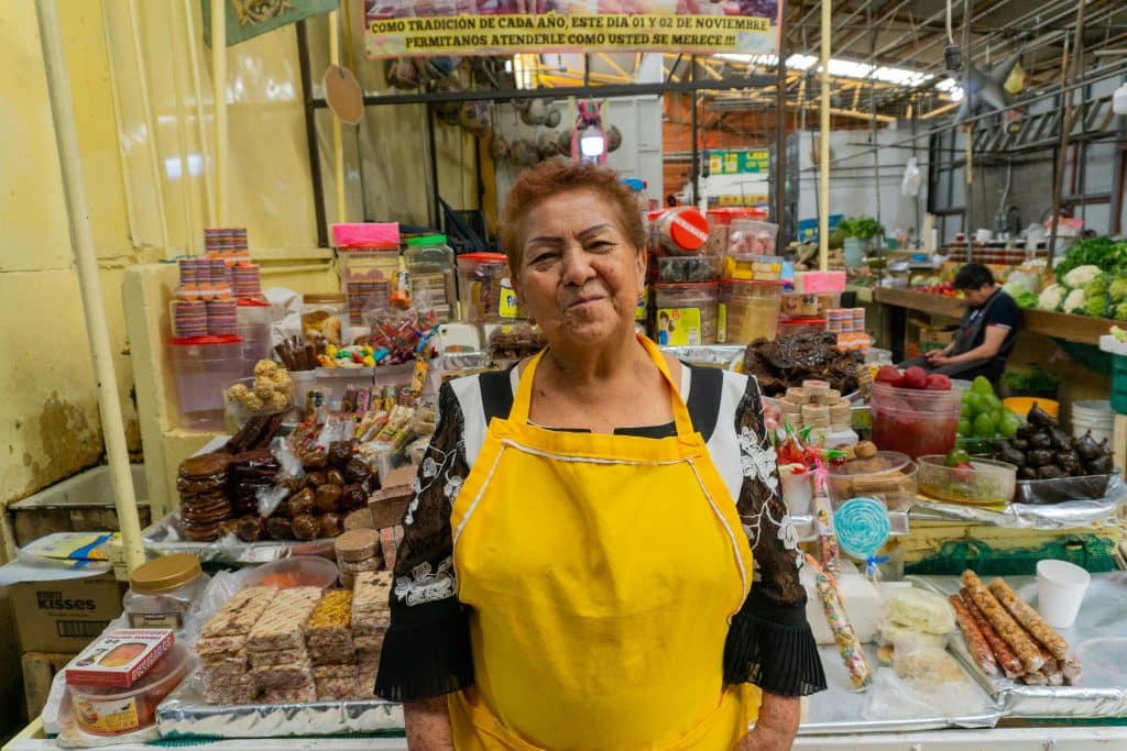 old latina woman in front of her food stand