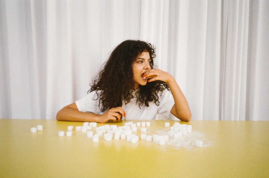 woman sitting in front of table with sugar cubes