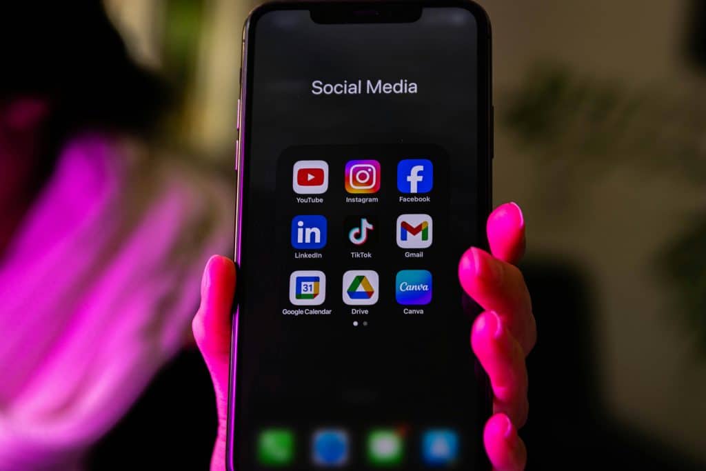 hand holding phone with social media apps
