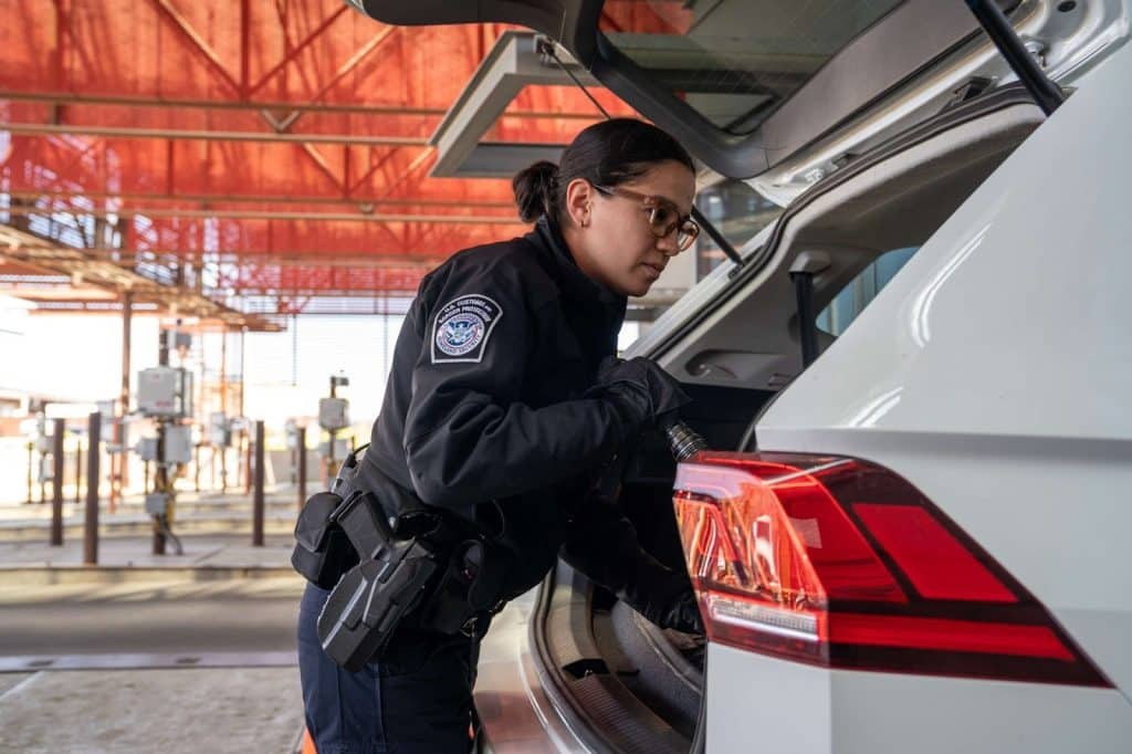 officer checking trunk of car