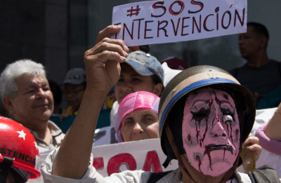 protestor wearing mask and holding up sign