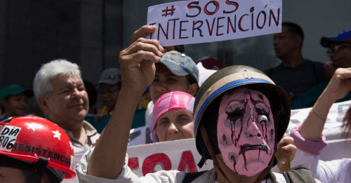 protestor wearing mask and holding up sign