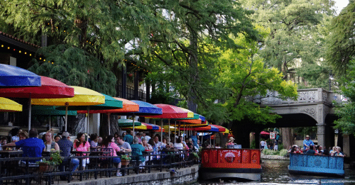 people sitting at cafes on the river walk
