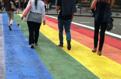 people walking on rainbow crosswalk