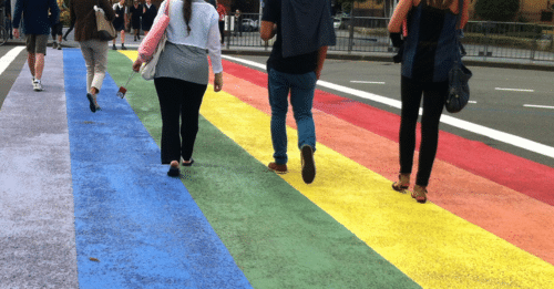 people walking on rainbow crosswalk