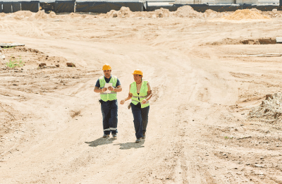 two construction workers walking in construction site