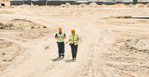 two construction workers walking in construction site