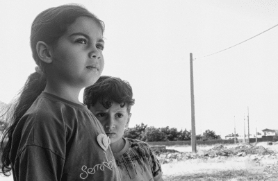 two children looking uncertainly towards the horizon