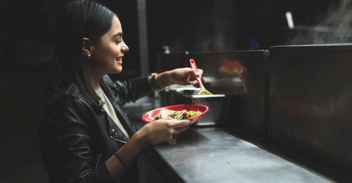 woman smiling with a taco in hand