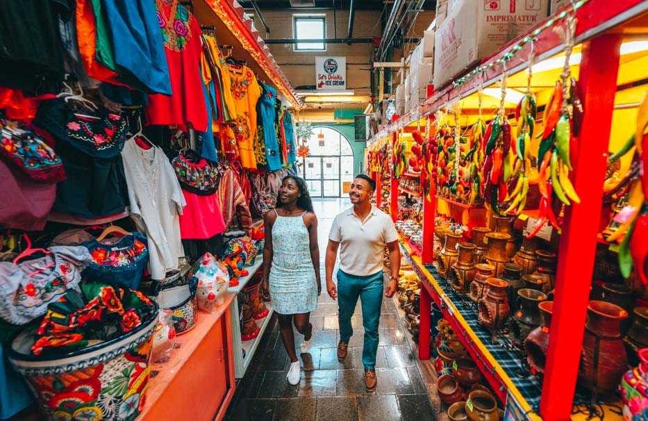 couple walking hand in hand through market