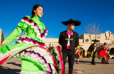 woman dressed in traditional attire dancing with mariachi