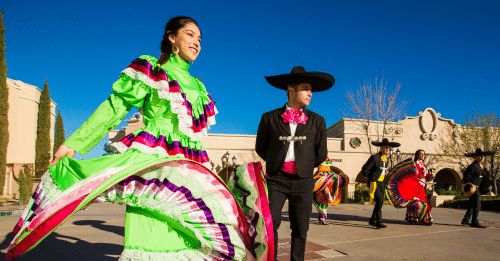 woman dressed in traditional attire dancing with mariachi