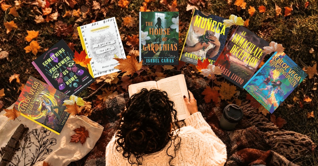 woman laying over fall leaves reading a book