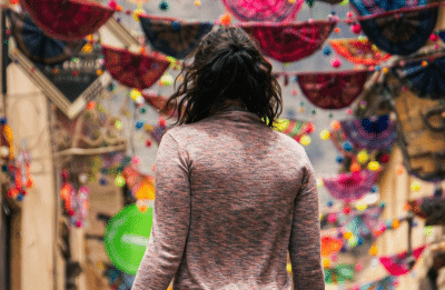 woman standing on empty parade route with her back to the camera