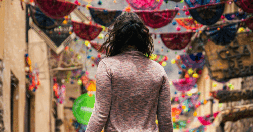 woman standing on empty parade route with her back to the camera